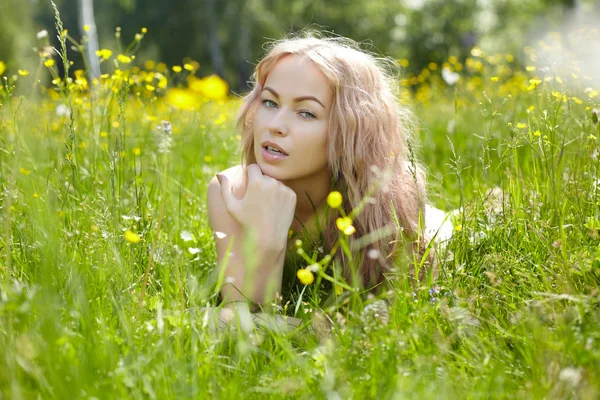 Blond kvinna lyin på fältet — Stockfoto