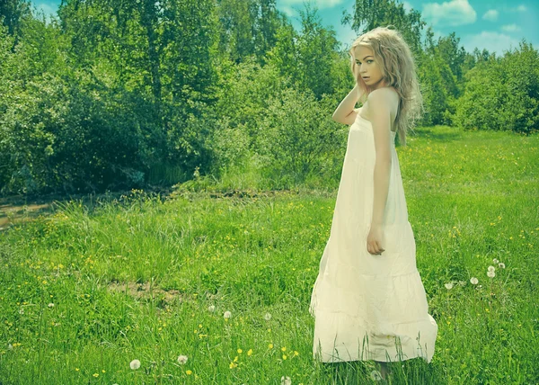 Mulher loira bonita na grama em vestido branco — Fotografia de Stock