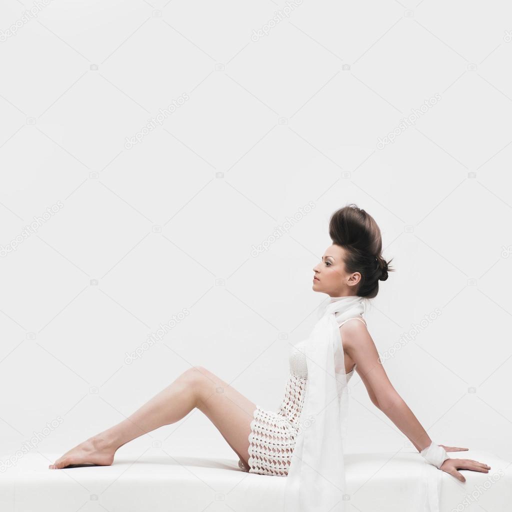 Elegant woman in white dress on white background