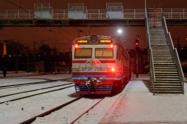 Kharkiv, Ukrayna - 28 Ocak 2022: Ukrayna 'nın eski elektrikli tren ER2R Kharkiv Yolcu Tren İstasyonu' ndaki istasyon peronundan kalkıyor. Gece fotoğrafı..