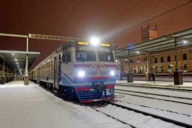 Kharkiv, Ukrayna - 28 Ocak 2022: Ukrayna 'nın eski elektrikli tren ER2R Kharkiv Yolcu Tren İstasyonu' ndaki istasyon peronundan kalkıyor. Gece fotoğrafı..