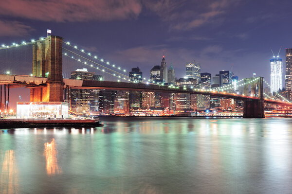 New York City Brooklyn Bridge with downtown skyline over East River.