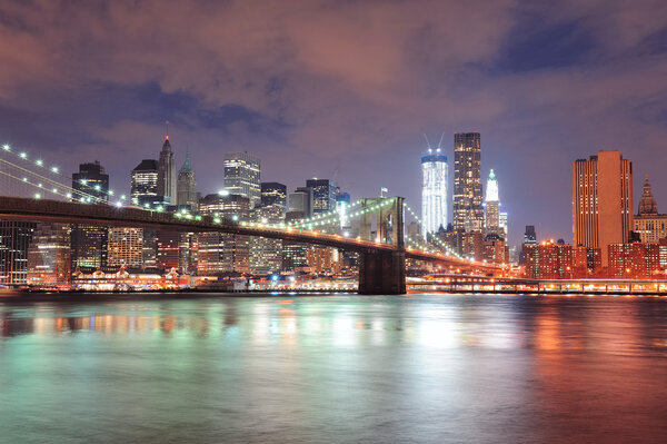 New York City Brooklyn Bridge with downtown skyline over East River.