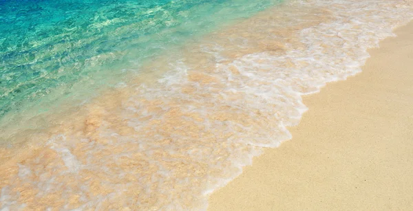 Färgstarka havet bevattnar på stranden — Stockfoto