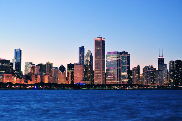 Chicago city downtown urban skyline at dusk with skyscrapers over Lake Michigan with clear blue sky.