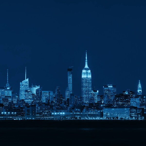 New York City skyline with skyscrapers over Hudson River viewed from New Jersey at night
