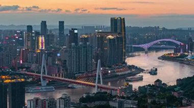 Chongqing şehrinin kentsel mimari manzarası ve Çin 'de gün batımından batımına kadar nehir üzerinde köprü.