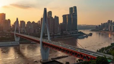Chongqing şehrinin kentsel mimari manzarası ve Çin 'de gün batımından batımına kadar nehir üzerinde köprü.