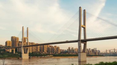 Chongqing şehri zaman çizelgesi. Gün batımından batımına kadar şehir merkezindeki gökdelen ve Çin nehri üzerindeki köprü manzarası.