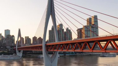 Chongqing şehrinin kentsel mimari manzarası ve Çin 'de gün batımından batımına kadar nehir üzerinde köprü.