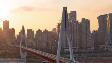 Chongqing şehrinin kentsel mimari manzarası ve Çin 'de gün batımından batımına kadar nehir üzerinde köprü.
