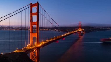 Golden Gate Köprüsü 'nün zaman ayarlı görüntüsü, San Francisco' nun ünlü simgesi olarak karanlık ve gün doğumundan gündoğumuna kadar.