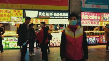 GUANGZHOU, CHINA - OCT 2, 2021: Urban city street view with stores and pedestrians