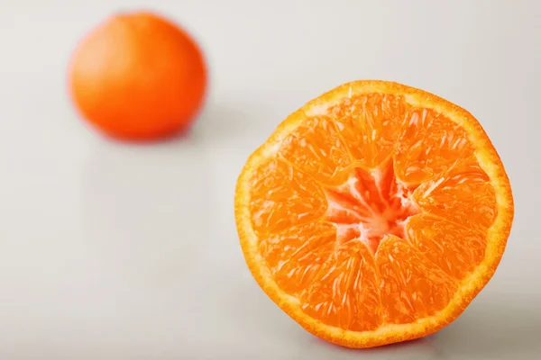 Очищений апельсин на зеленому фоні — стокове фото