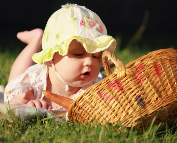 Güzel kız bebek sepeti sebze ile görünüyor. — Stok fotoğraf