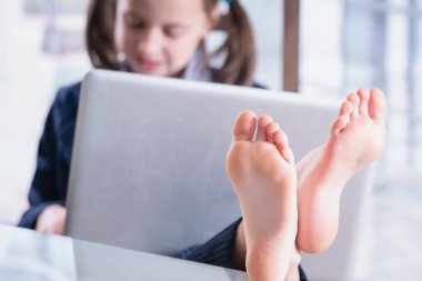 Ofiste çalışan iş çocuğunun komik bir fotoğrafı. Yatay görüntü. Çıplak ayaklara odaklan.
