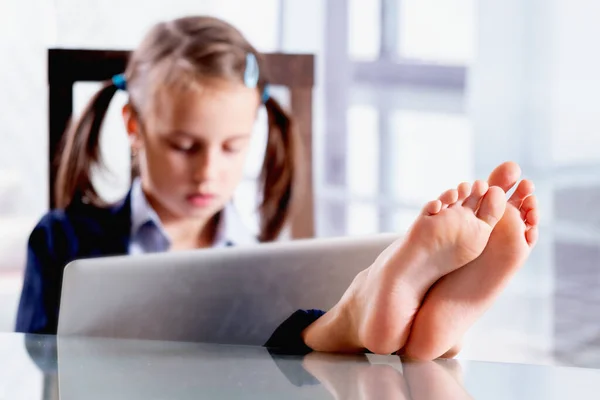 Masanın üzerinde çıplak ayaklı bir iş çocuğunun komik portresi kilit altında tutulduktan sonra ofiste çalışıyor. Çıplak ayaklara odaklan