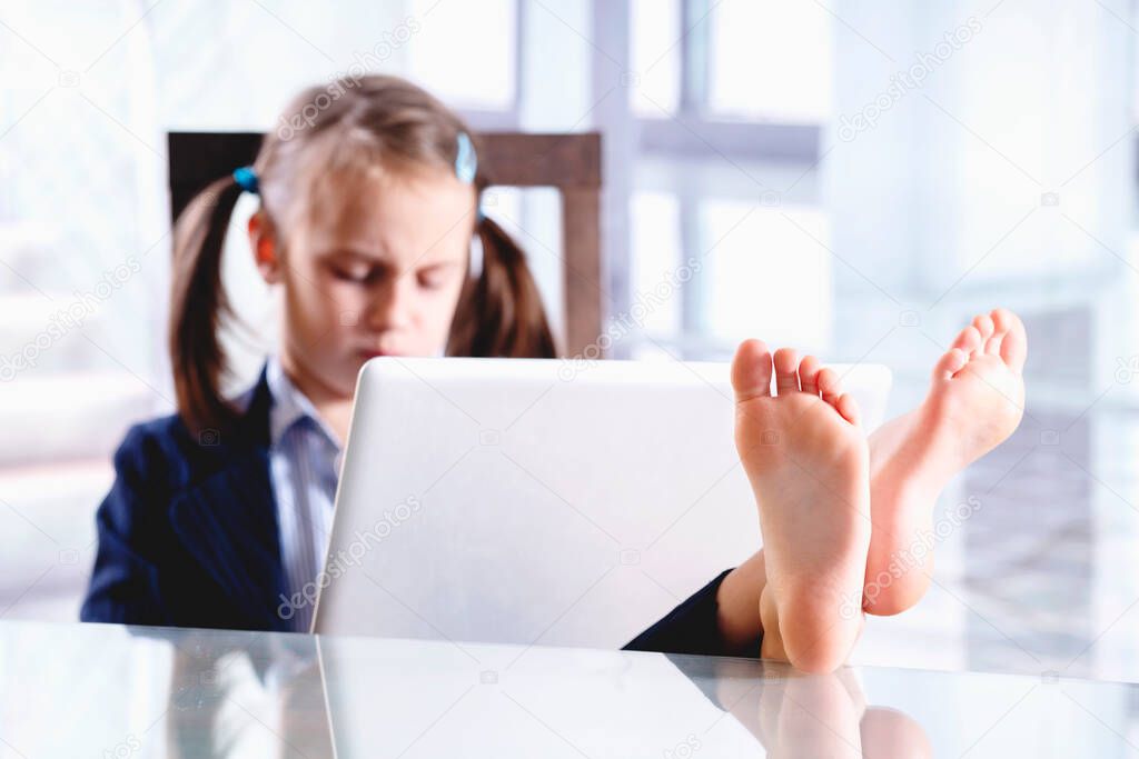 Sad and tired young beautiful  business girl working in office with bare feet up. Selective focus on feet.