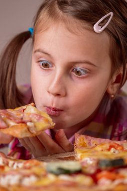 Genç ve çekici bir kızın komik portresi sokak pizzası yiyor. Gözlere odaklan. Dikey resim.