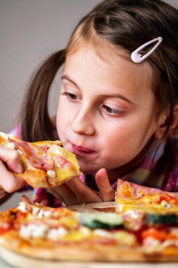 Güzel ve çekici bir kızın portresi sokak pizzası yiyor. Aç kadın çocuk içeride.