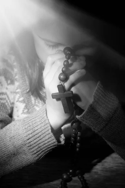 木製のロザリオで神に祈る若い美しい少女の肖像画 クロスに焦点を当てます 白黒の画像 — ストック写真