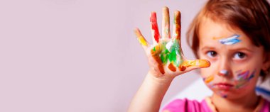 Renkli boyalı elleri olan güzel bir kız çocuğu. Yatay görüntü. Elimizdeki seçici odaklanma. Boşluğu kopyala.