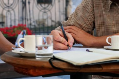 İki işadamı projede çalışıyor, gülüyor ve kahve içiyor..