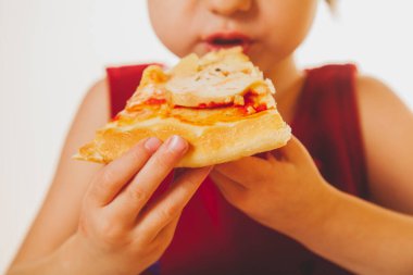 Güzel bir kız çocuğu lezzetli bir dilim pizzayı seviyor, bu tadı seviyor, iyi bir iştahı var.