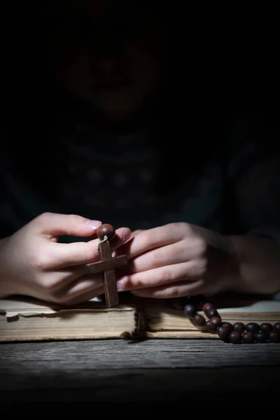若い美しい少女は木製のロザリオで神に祈る クロスと手に焦点を当てる — ストック写真