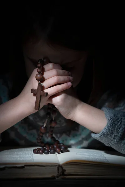 若い美しい少女は木製のロザリオで神に祈る 縦の画像 クロスに焦点を当てる — ストック写真