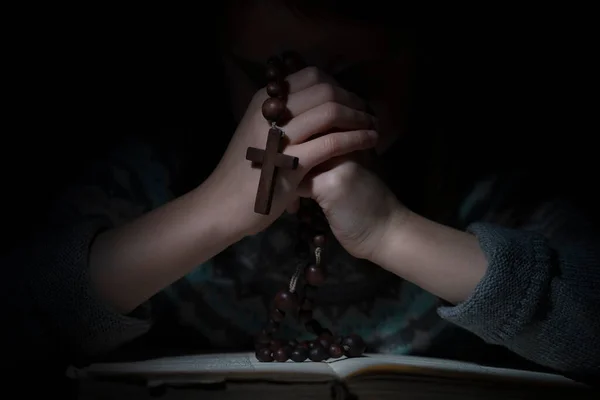 若い女の子は神にロザリオを祈っています 子供の選択的焦点目 — ストック写真