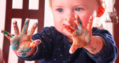 Güzel küçük bir kızın renkli boyalı elleri