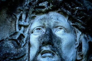 Dikenli bir taç içindeki antik İsa heykeli.