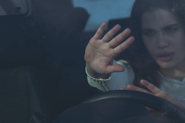 Portrait of stressed and confused woman panics in a dangerous situation on the road while driving