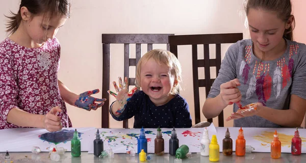 Tüm yaştaki çocuklar için sanat dersleri. Boyalı elleriyle resim çizen mutlu çocuklar.