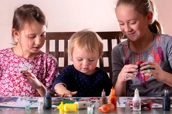 Boyalı elleriyle resim çizen mutlu çocuklar. Tasasız mutlu çocukluk, sanat ve yaratıcılığı öğrenme kavramı. Yatay resim.