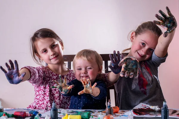Boyalı elli mutlu çocuklar çiziyor ve eğleniyorlar. Tasasız mutlu çocukluk, öğrenme sanatı ve yaratıcılık. 
