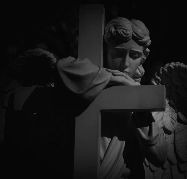 イエス キリストの死と復活 キリスト教のシンボルとして十字架を持つ天使の古代の像の黒と白のイメージ — ストック写真