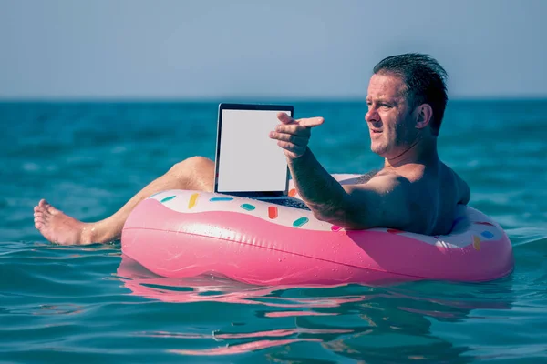 Mann Arbeitet Mit Laptop Aufblasbarem Ring Wasser Und Zeigt Mit — Stockfoto