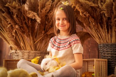 Beyaz tavşanlı çok mutlu bir genç kızın portresi. Paskalya konsepti.