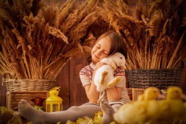 Beyaz tavşan ve küçük ördekleri olan güzel bir kızın paskalya portresi..
