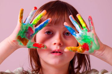 Renkli boyalı elleri olan güzel bir genç kızın portresi. Sanat ve yaratıcılık kavramı
