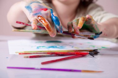 Selamlama sanatçısının komik bir görüntüsü. Fırçayla resim yapan genç bir kız. Sanat, çocukluk, öğrenme ve yaratıcılık kavramı.