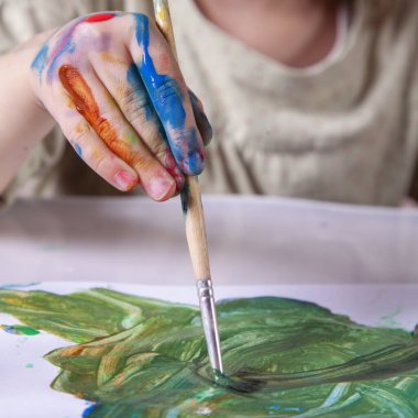 Fırçayla resim yapan güzel bir kızın portresi. Sanat, çocukluk, öğrenme ve yaratıcılık kavramı. Kapat..