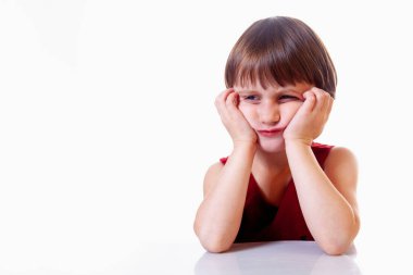 Beyaz arka planda üzgün, yorgun ve bitkin bir kız çocuğunun portresi. Jestler, vücut dili, yüz ifadeleri ve depresyon konsepti. Tasarım için boş alan.