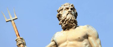 Deniz ve okyanus tanrısı Neptün (Poseidon) mavi gökyüzü arka planına karşı. Antik bir heykelin parçası..