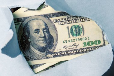 Yüz dolarlık banknotlarla dokulu kağıt arka plan yüzeyi yırtılmış. Kapatın. Ekonomik çatışma ve kriz, yaptırım kavramı. 