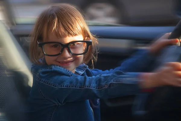 Driving shool. Funny portrait of young girl learns to drive. Selective focus on eyes.