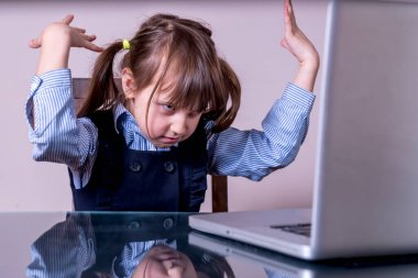Çocukların fiziksel ve zihinsel sağlıklarında günlük hayatta dijital cihazların aşırı kullanımı tehlikesi. Dizüstü bilgisayarın önünde oturan çok kızgın bir genç kız. 