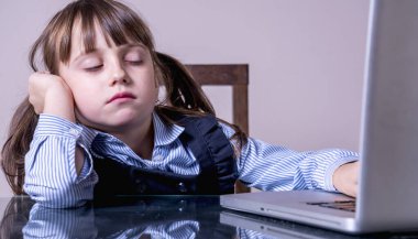 Çocuklar için çevrimiçi eğitim. Çocukların fiziksel ve zihinsel sağlıklarında günlük hayatta dijital cihazların aşırı kullanımı tehlikesi. Bilgisayarı olan kız çocuğu